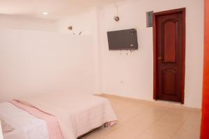 a room with a bed and a tv on a wall at confortable apartaestudio norte, frente CC Alamedas in Pringamosa
