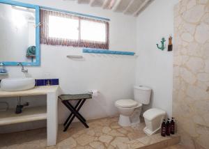 a white bathroom with a sink and a toilet at Santa Ana Del Mar House Your Beachfront Escape in Trementino
