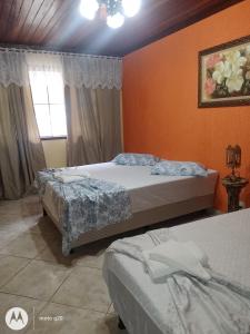a bedroom with two beds and a window at Sossego da Mamãe in Paraty