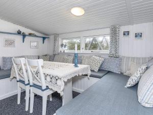 a room with a table and chairs and a couch at 8 person holiday home in Løgstør-By Traum in Trend +12 photos