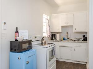 a kitchen with white cabinets and a microwave at Solvang Bungalow B in Solvang