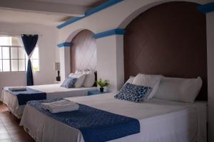 2 Betten in einem blau-weißen Zimmer in der Unterkunft Casa Coral in Los Cóbanos