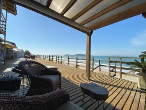 a deck with chairs and a view of the ocean at Hibisco Guest House in Florianópolis