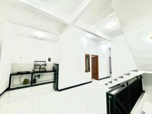 a room with white walls and a black and white floor at Han Gang Syariah in Ponorogo
