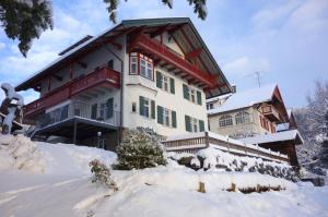 ein großes Haus mit Schnee davor in der Unterkunft Villa Bergfrieden in Oberstaufen