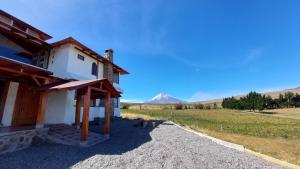 una casa con una montaña al fondo en Cotopaxi Lodge, en Hacienda Porvenir