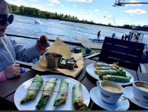 a table with plates of food on a boat at Cottage with fireplace and sauna in Pakalniškės