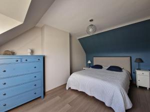 a bedroom with a bed and a blue wall at Holiday Home in Paimpol near Beach in Paimpol