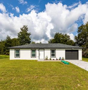 a white house with a large yard at Ocala Modern Oasis 5 minutes to World Equestrian Center in Ocala