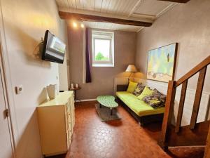 Una pequeña sala de estar con un sofá y un televisor. en Charmante maison près des Châteaux de la Loire, jardin, wifi - FR-1-381-371, en Athée-sur-Cher