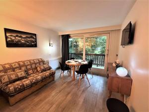 un salon avec un canapé et une table avec des chaises dans l'établissement Studio skis aux pieds, 3 pers, centre Méribel, balcon, TV, fibre - FR-1-180-638, à Les Allues