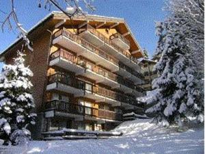 un grand immeuble avec de la neige au sol dans l'établissement Studio skis aux pieds, 3 pers, centre Méribel, balcon, TV, fibre - FR-1-180-638, à Les Allues