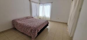 a bedroom with a bed with a purple blanket and a window at Casa Grande Alisos in San Salvador de Jujuy +10 photos