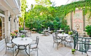 an outdoor patio with tables and chairs and vines at Relais & Châteaux Hotel Orfila in Madrid