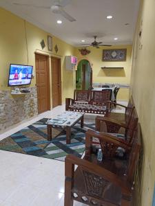 a living room with couches and a flat screen tv at Husna Homestay Kota Harmoni Tanah Merah in Tanah Merah