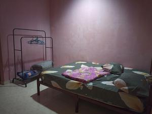 a bedroom with a bed with a green comforter at Husna Homestay Kota Harmoni Tanah Merah in Tanah Merah +1 photo