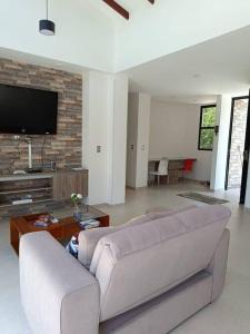 a living room with a couch and a tv at Avemaría! in Puente Nacional