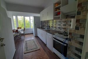 a kitchen with white cabinets and a stove top oven at Bahceli ev 