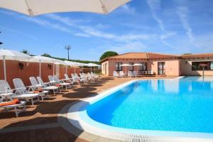 a large swimming pool with chairs and umbrellas at Apartment in Vignola Mare near Sandy Beach in Vignola Mare +36 photos