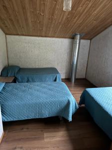 プエルト・プユワピにあるcabañas mateo 01の木製天井のドミトリールームのベッド2台分です。