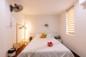 Un dormitorio con una cama blanca con flores. en Minh Anh Homestay 2, en Thôn Trường Giang