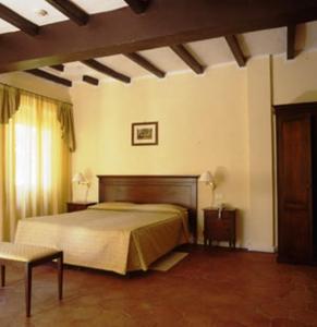 a bedroom with a bed and a chair in a room at Hotel Ca' Vecchia in Sasso Marconi
