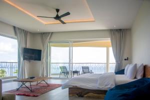 Un dormitorio con una cama y un ventilador de techo. en Chaweng Noi Ocean View Villa, en Nathon Bay