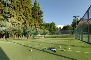 a tennis court with a tennis racket and a tennis ball at Parador de Cordoba in Córdoba