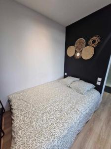 a bedroom with a bed with a black headboard at Studio Canada 3 in Valenciennes