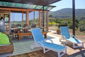 a patio with two blue chairs and a wooden table at Holiday Home Magazzini with Sea View in Magazzini +16 photos