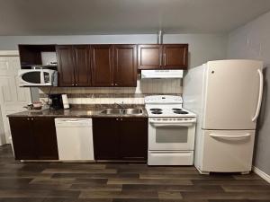 a kitchen with a white refrigerator and a sink at Arrow Lake Motel in Fauquier