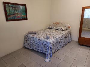 a small bed in a bedroom with a picture on the wall at Newtown Beach Bed and Bath in Nadi +17 photos
