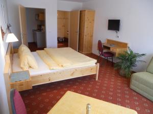 フラッハウにあるFerienhaus Oberbergのベッド、デスク、ソファが備わる客室です。