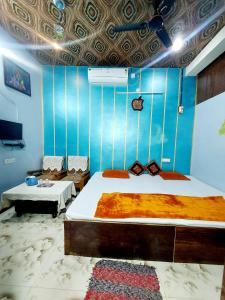 a bedroom with two beds and a blue wall at Mangal kripa homestay in Ujjain