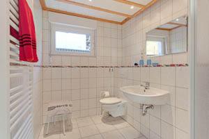 a white bathroom with a sink and a toilet at Ferienhaus Ostseeblick in Göhren +10 photos