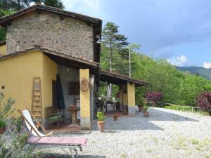 a building with a chair and a table in front of it at Beautiful Cottage in Pescia in San Quirico