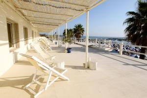 eine Reihe weißer Stühle am Strand in der Unterkunft Hotel Bagni Lido in Vada