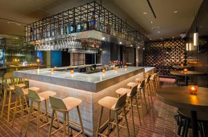 eine Bar in einem Restaurant mit Stühlen und Tischen in der Unterkunft The Time New York, part of JdV by Hyatt in New York