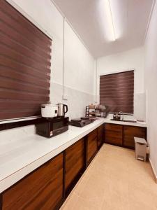 a kitchen with a counter top with a microwave at RumaRosa Kota Bharu in Kota Bharu