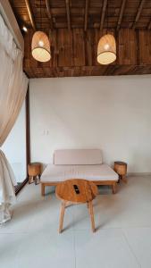 a room with a bed and a table and lights at Capila Villa Bali in Canggu