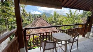 a table and chairs on a balcony with a view at Pondok Masa Depan in Sidemen