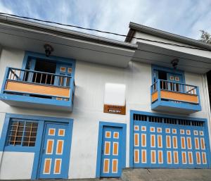 a house with blue and orange doors and a balcony at Apartahotel Casa Azul Salento in Salento