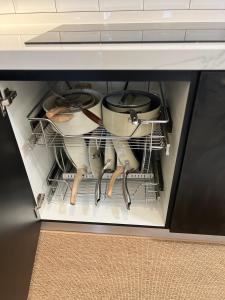 Un cajón lleno de ollas y sartenes en un armario. en amliza homestay, en Cyberjaya 8 fotos más