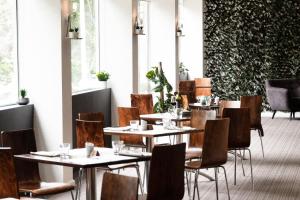 a restaurant with tables and chairs in a room at Mercure North Melbourne in Melbourne