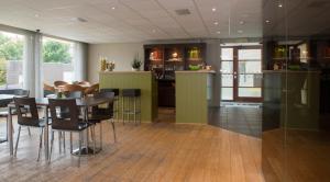 a kitchen and dining room with a table and chairs at Hotel Maxim in De Panne