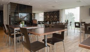 a dining room with wooden tables and chairs at Hotel Maxim in De Panne