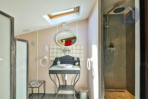 a bathroom with a sink and a shower at Les Chambres de la Forge des Collines in Les Herbiers