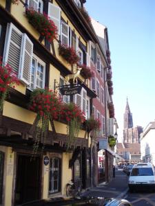 a building with flowers on the side of a street at Hotel Restaurant Au Cerf d'Or in Strasbourg