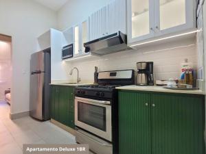 a kitchen with green cabinets and a stove at Heritage Residences Santo Domingo in Santo Domingo