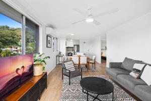 a living room with a couch and a table at Salty Sea Breeze Apartment 500m to waters edge in Gold Coast